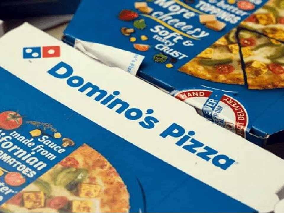 This picture depicts two pizza boxes with the branding of Domino’s Pizza