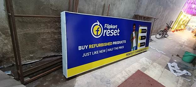 Flipkart refurbished products advertisement on a roadside display board showing discounted electronics