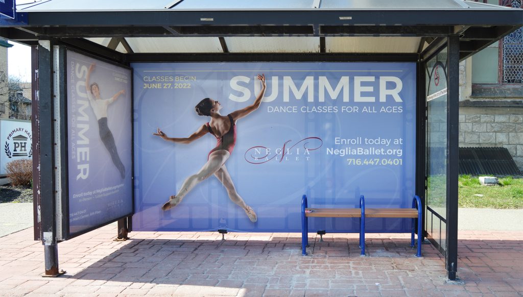 Summer Dance Classes Bus Shelter Advertisement Bus shelter advertisement featuring a ballerina mid-leap promoting summer dance classes for all ages, with enrollment details and website information on a blue background.