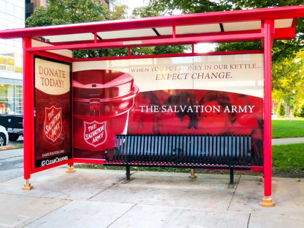 Red bus shelter wrapped with Salvation Army donation campaign advertisement