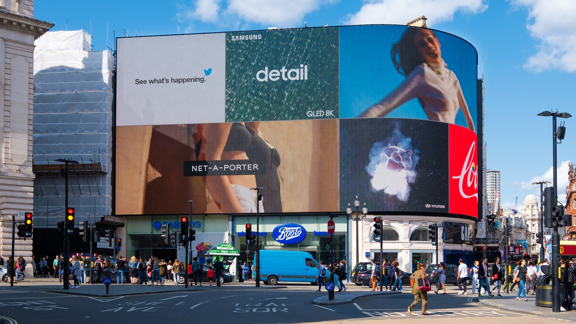 Large digital billboard in a busy city displaying multiple brand advertisements showcasing programmatic OOH advertising
