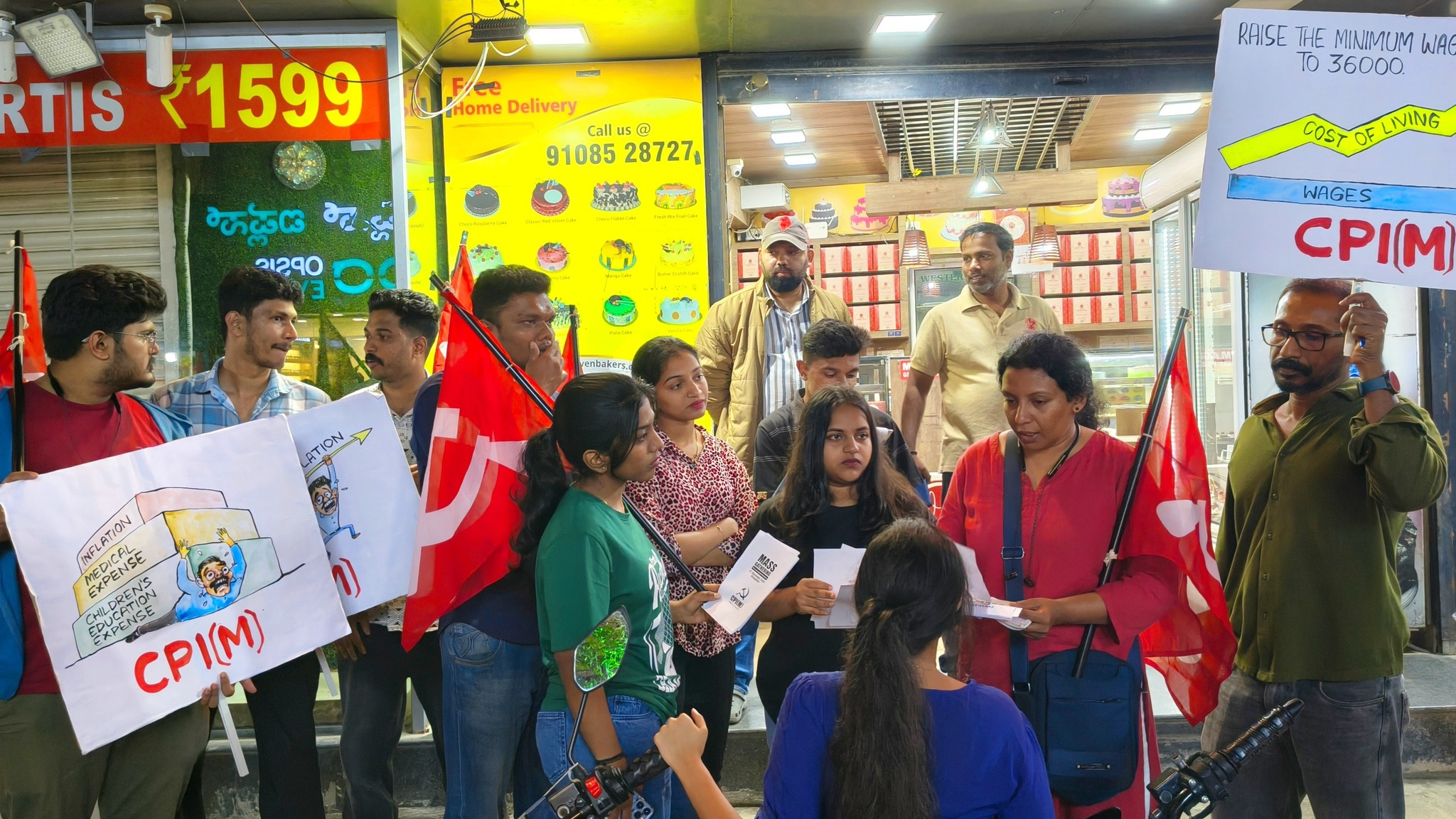 CPI(M) activists holding red flags and placards demanding minimum wage increase to 36000 rupees on a street in Bengaluru, Karnataka