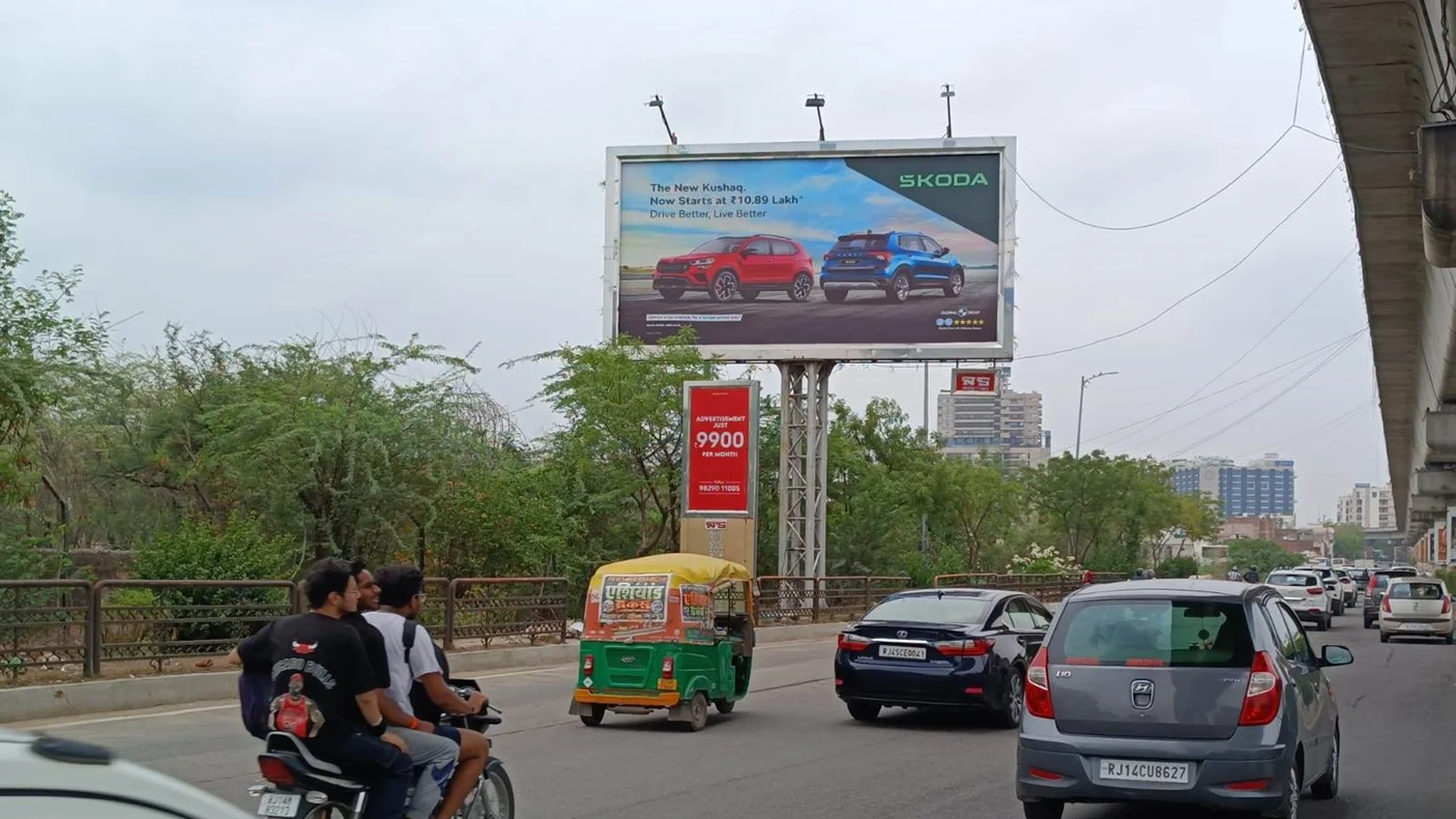 Skoda SUV outdoor advertising billboard in urban traffic environment Skoda car billboard showcasing SUV models placed above city road with vehicles and metro line