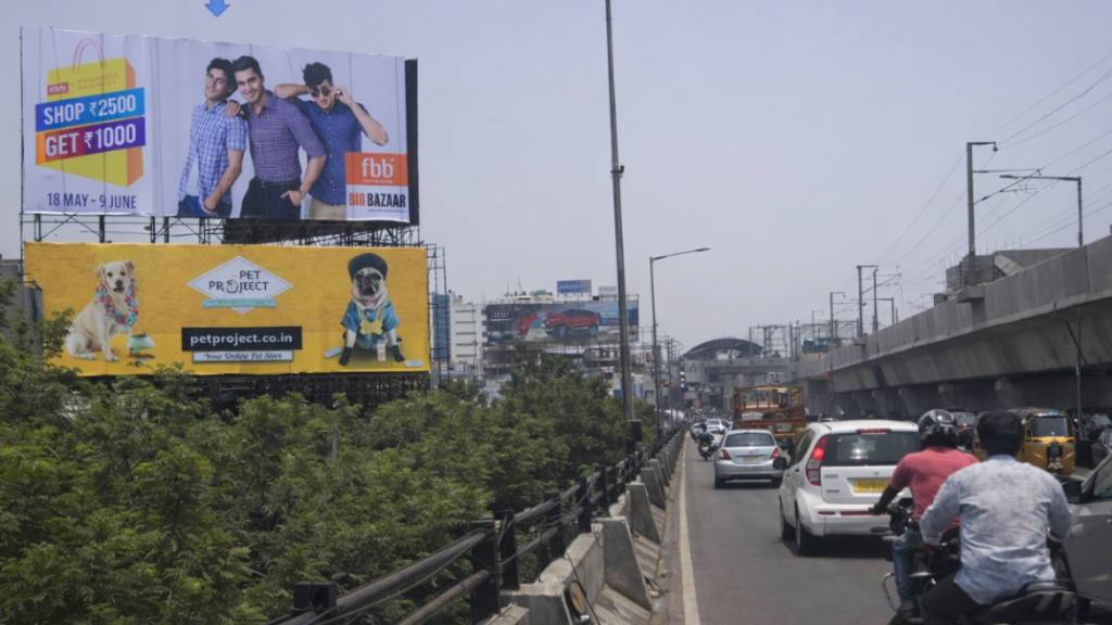 Retail and pet brand outdoor advertising billboards in Indian city Fashion Big Bazaar and Pet Project billboards displayed along busy urban road with traffic