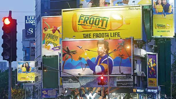 Frooti outdoor advertising campaign showcasing brand storytelling Frooti mango drink billboard campaign with vibrant visuals and brand ambassador in busy city street