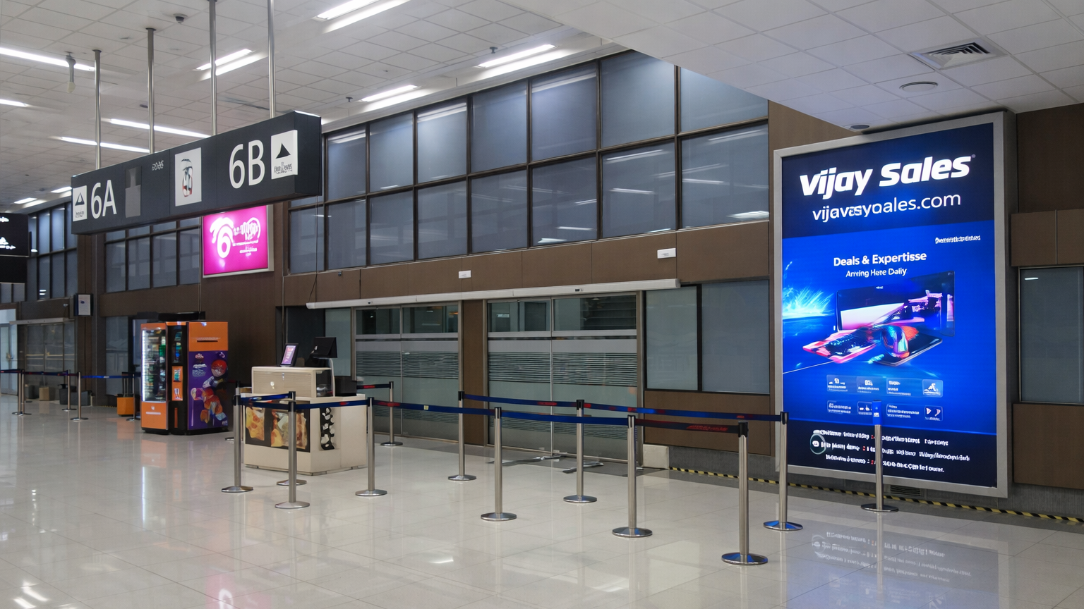 Airport boarding gate area displaying a tall digital advertisement for Vijay Sales electronics store near Gate 6A and 6B.
