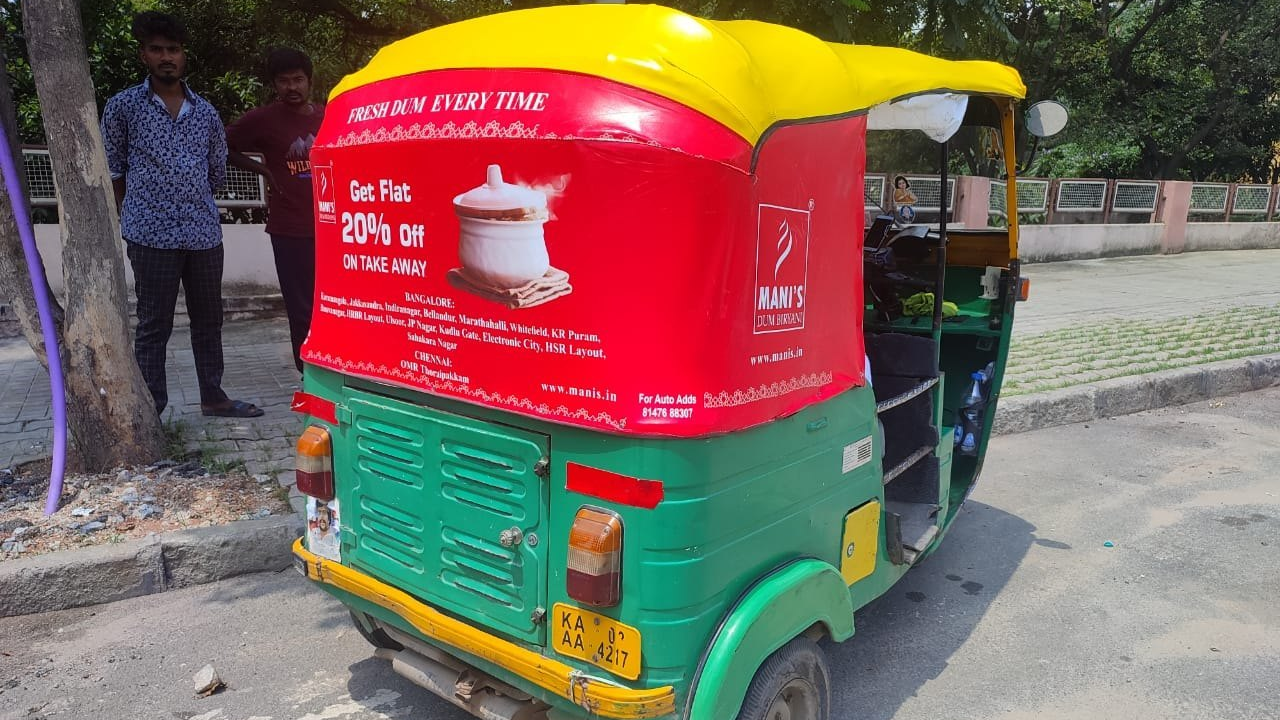 Auto rickshaw back panel advertisement for Mani’s Dum Biryani offering takeaway discount in hyperlocal transit media