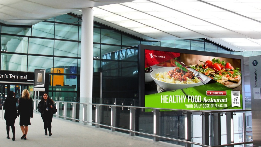 Digital advertising screen inside airport terminal promoting restaurant brand to travelers