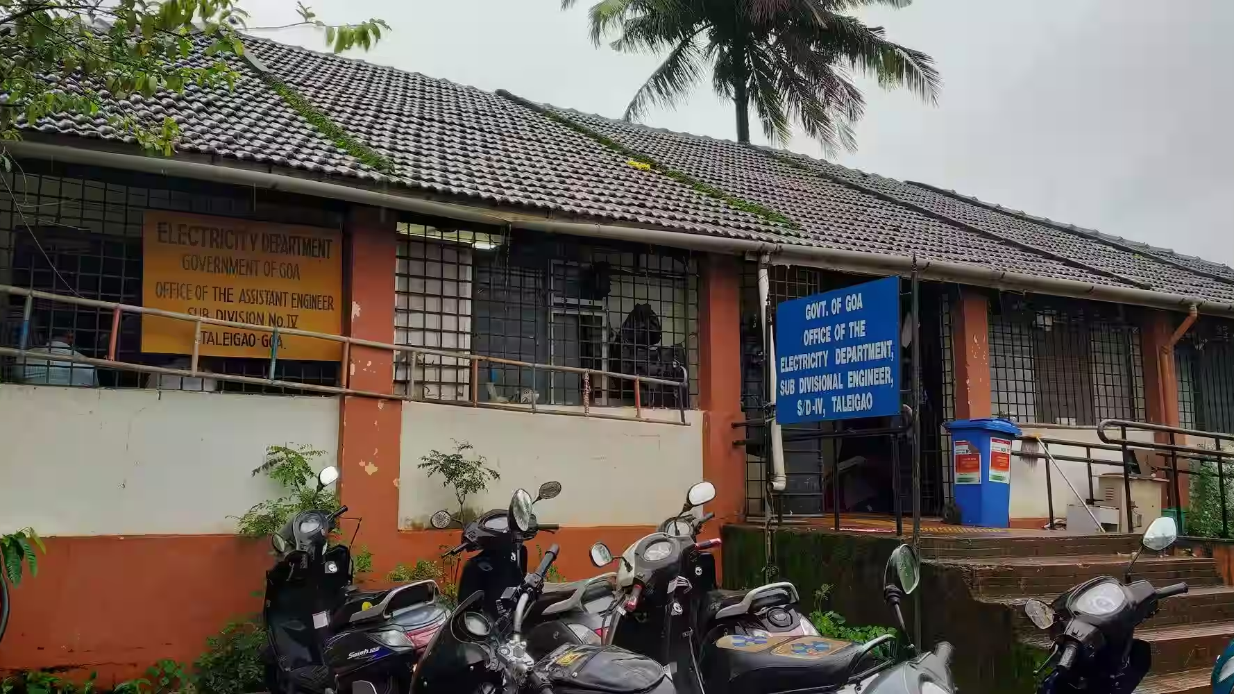 Government electricity department office building in Goa with parked scooters outside