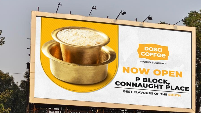 Outdoor billboard advertising Dosa Coffee restaurant opening at Connaught Place featuring traditional South Indian filter coffee visual