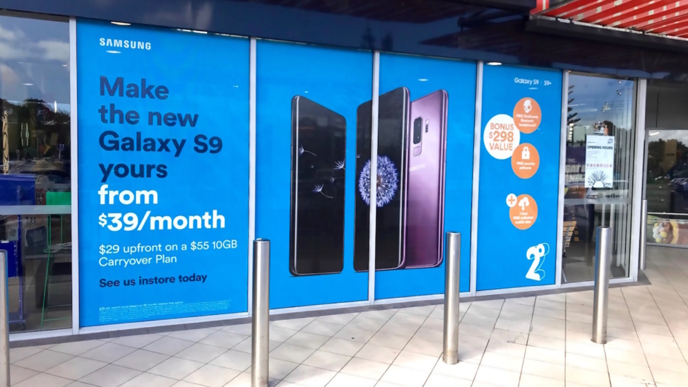 storefront glass advertising for Samsung Galaxy S9 promotion in retail shopping area
